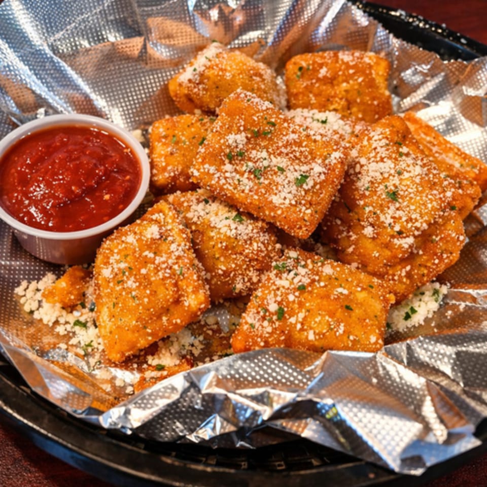 Golden-brown fried ravioli, sprinkled with Parmesan cheese and parsley, served with a side of marinara sauce.